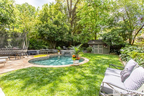 A backyard with a pool and a patio.