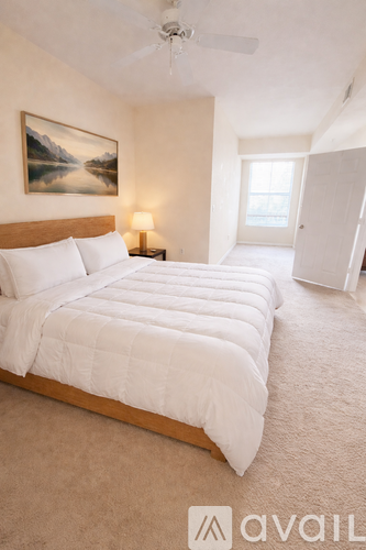 A bedroom with a large bed and a painting on the wall.