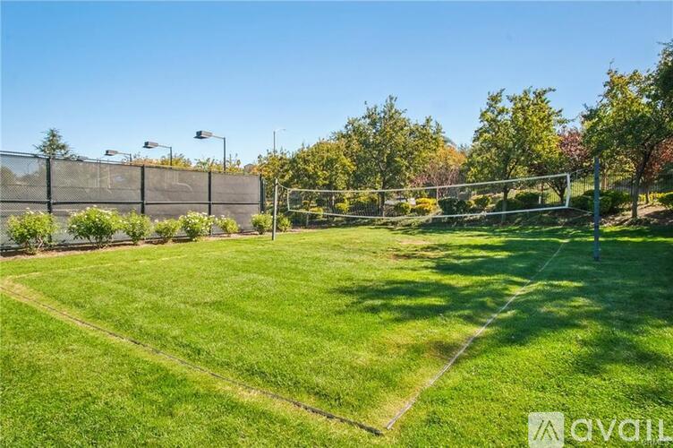 A tennis court surrounded by a fence and trees.