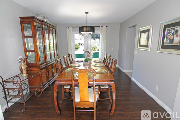 A dining room with a wooden table and chairs.