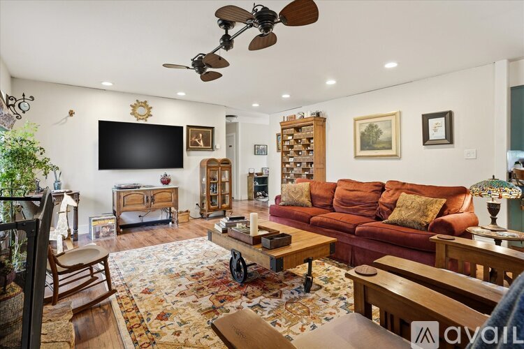 A living room with a red couch and a rug with a pattern on it.