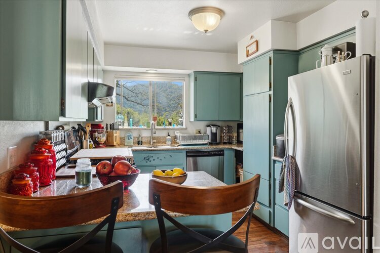 A kitchen with a table and chairs in front of it.