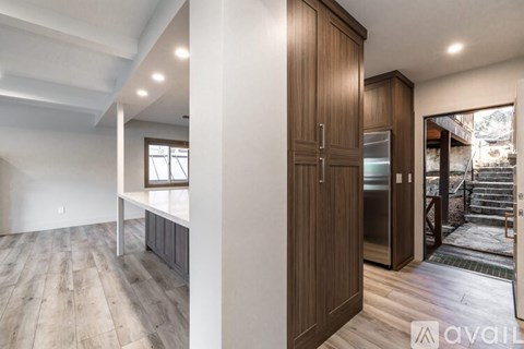A modern kitchen with wooden cabinets and a stainless steel refrigerator.