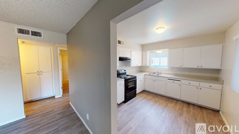 A kitchen with white cabinets and a black dishwasher.