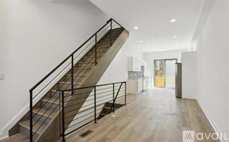 A staircase with a metal railing and wooden steps leads to another room.