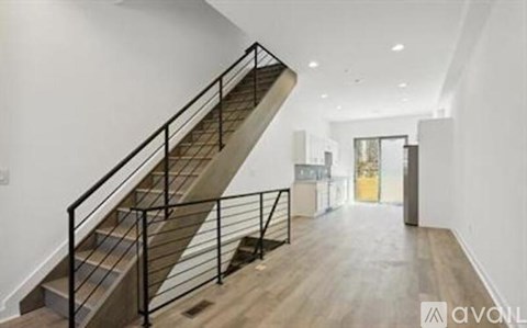 A staircase with a metal railing and wooden steps leads to another room.