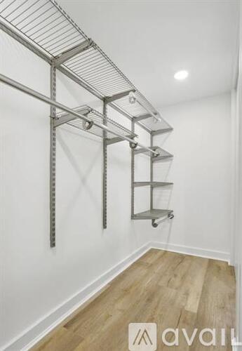 A white wall with a metal shelving unit on wheels.
