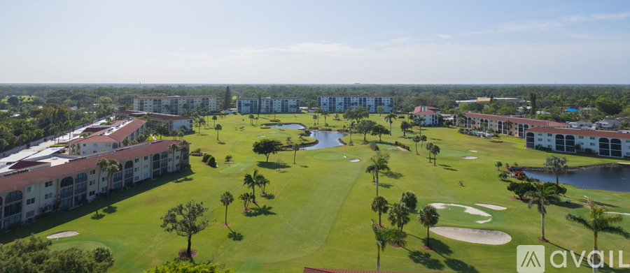 A golf course with a clubhouse and palm trees.