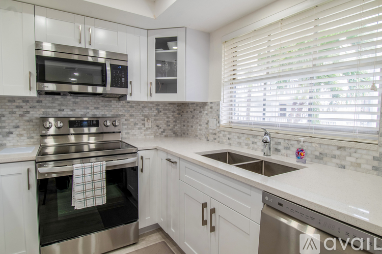 A kitchen with white cabinets and a stainless steel oven.