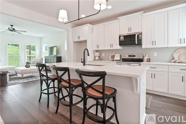 A kitchen with white cabinets and a black countertop.