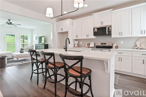 A kitchen with white cabinets and a black countertop.