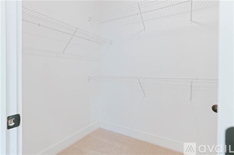 A room with a white door and a carpeted floor.
