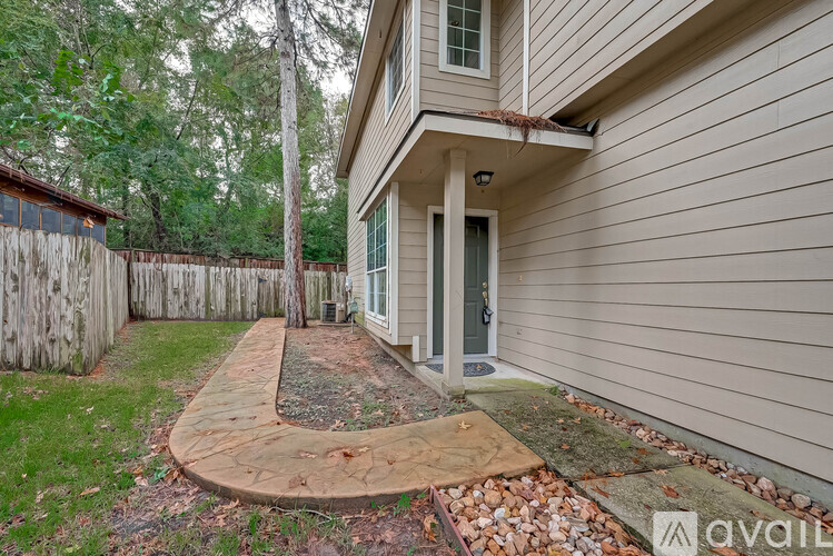 A house with a grey siding and a green door is for sale.