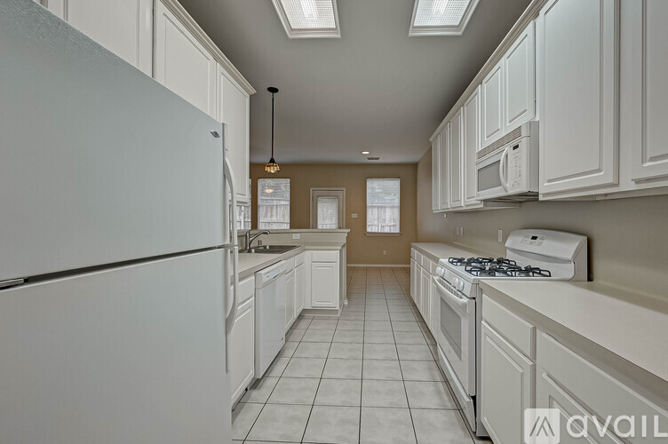 A kitchen with white appliances and cabinets.