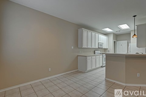 A kitchen with white cabinets and appliances is available for rent.