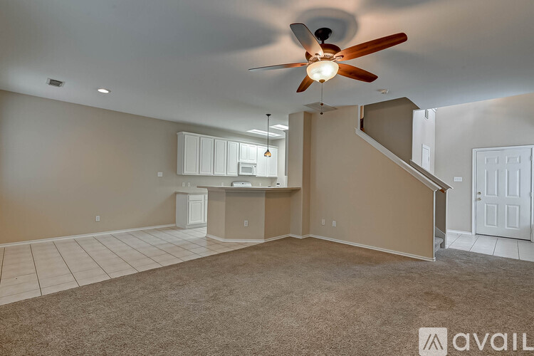A spacious room with a ceiling fan and carpeted floor.