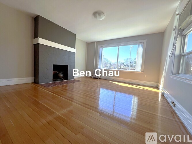 A living room with a fireplace and a large window.