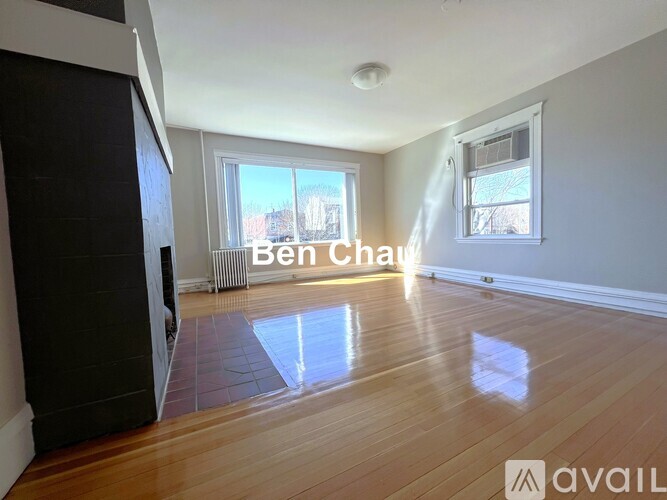 A room with wooden flooring and a window letting in light.