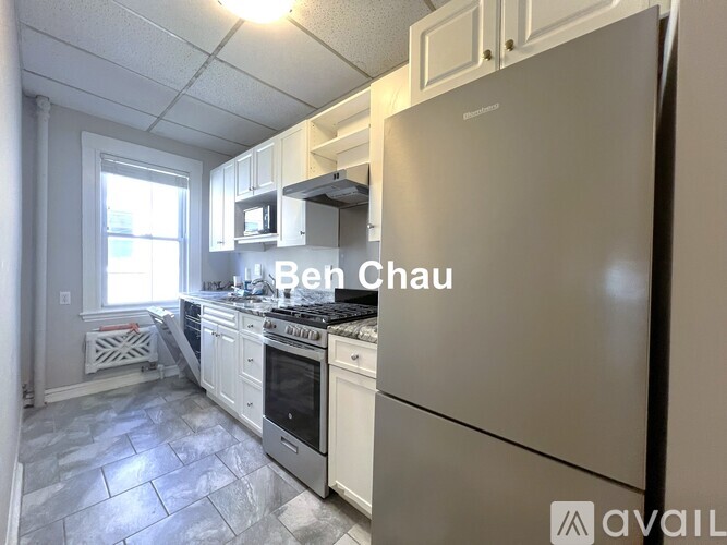 A kitchen with a refrigerator, oven, and microwave.