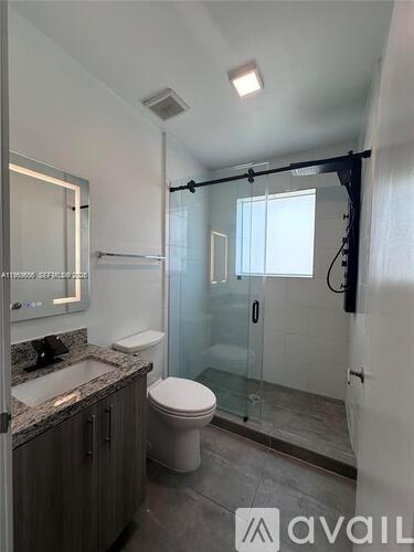 A bathroom with a toilet, sink, and shower.