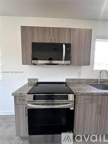 A kitchen with a black oven and microwave above it.