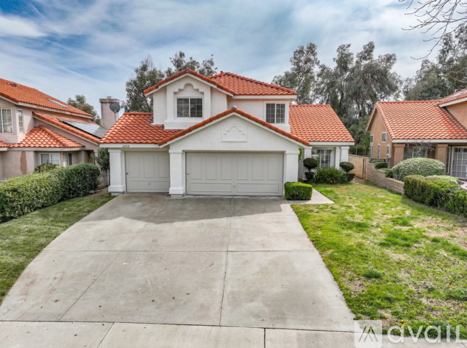 A house with a red tiled roof and a white garage door.