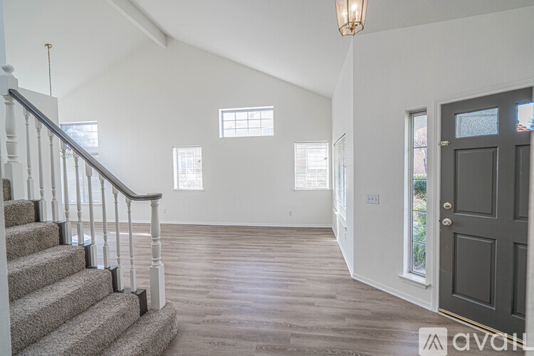 A spacious room with a staircase leading to the upper floor.