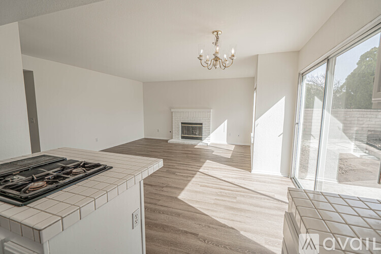 A modern kitchen with a stove top oven and a chandelier.