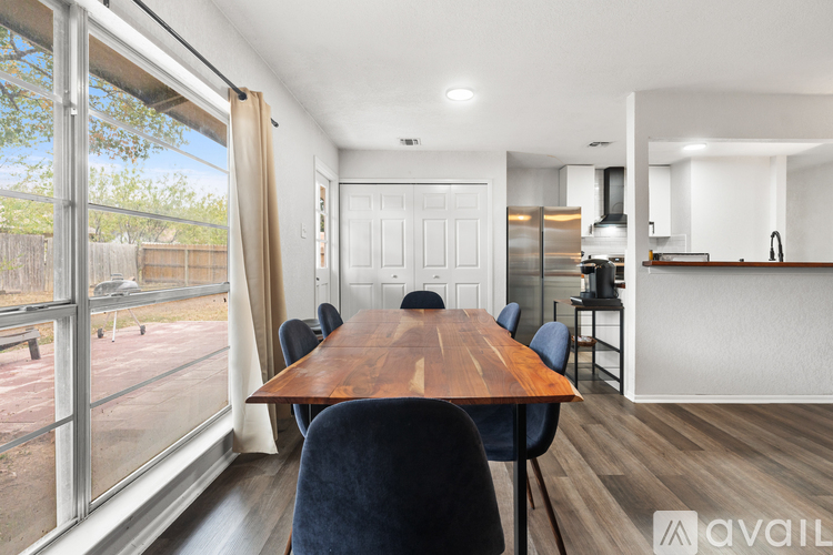 A modern kitchen with a wooden dining table and chairs.