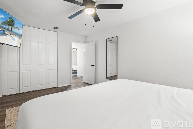 A bedroom with a large bed and a television showing a beach scene.