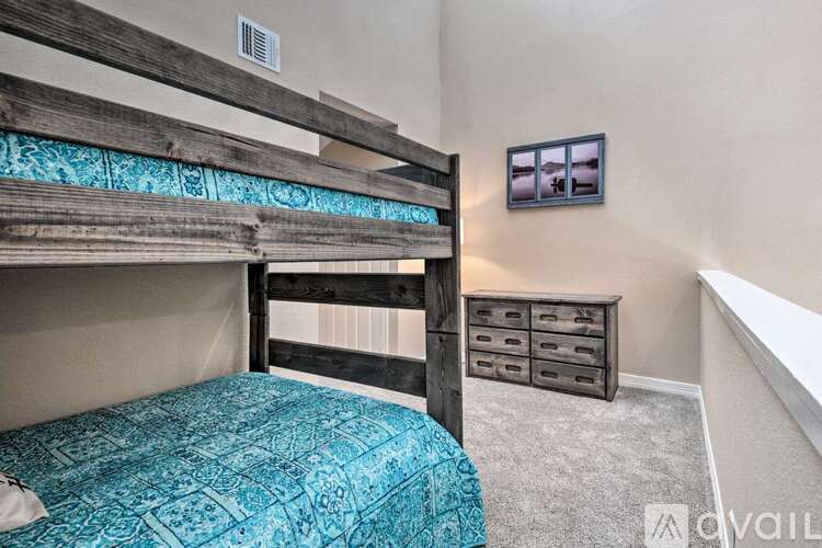 A bedroom with a bunk bed and a dresser.