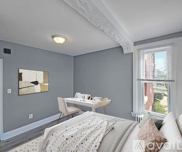 A bedroom with a bed, desk, and chair.