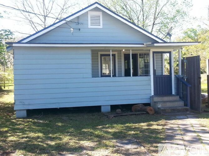 A small blue house with a white door and windows.