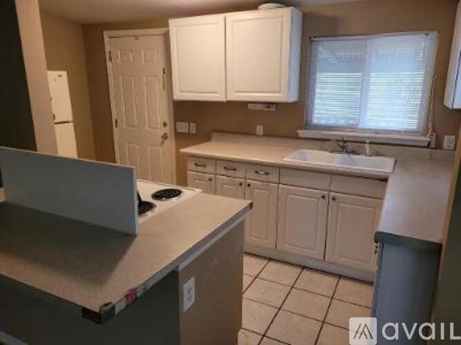 A kitchen with white cabinets and a stainless steel island.