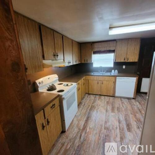 A kitchen with wooden cabinets and a white stove top oven.