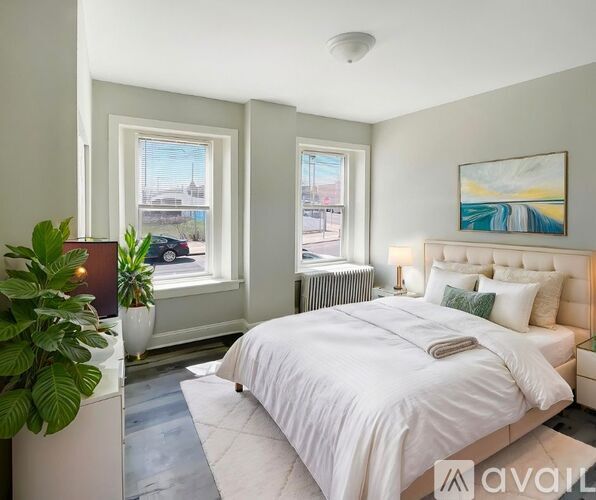 A bedroom with a large bed and a window overlooking a cityscape.