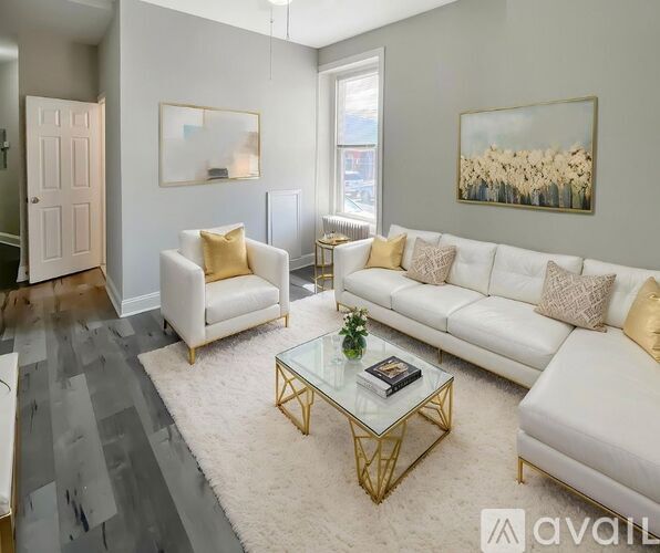 A living room with a white couch, a coffee table, and a painting on the wall.