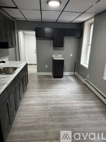 A kitchen with dark wood cabinets and a white sink.