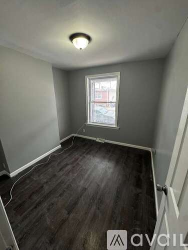 A room with a window and wooden flooring.