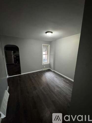 A room with a window and a wooden floor.