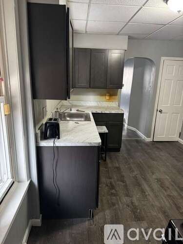 A kitchen with dark wood cabinets and a marble countertop.