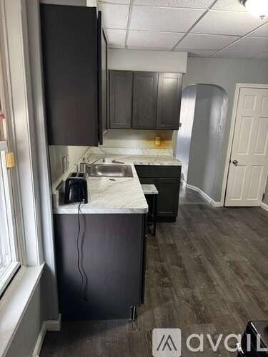 A kitchen with dark wood cabinets and a marble countertop.