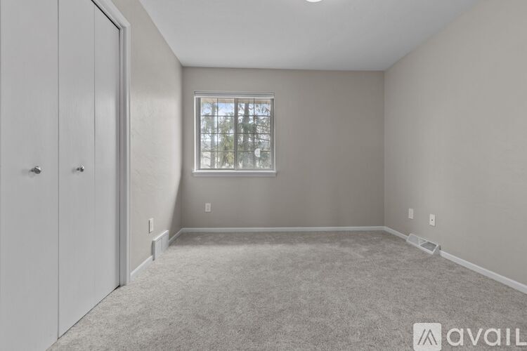 A room with a carpeted floor and a window.
