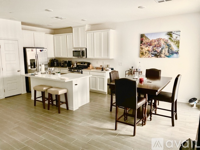 A kitchen with a table and chairs in front of it.