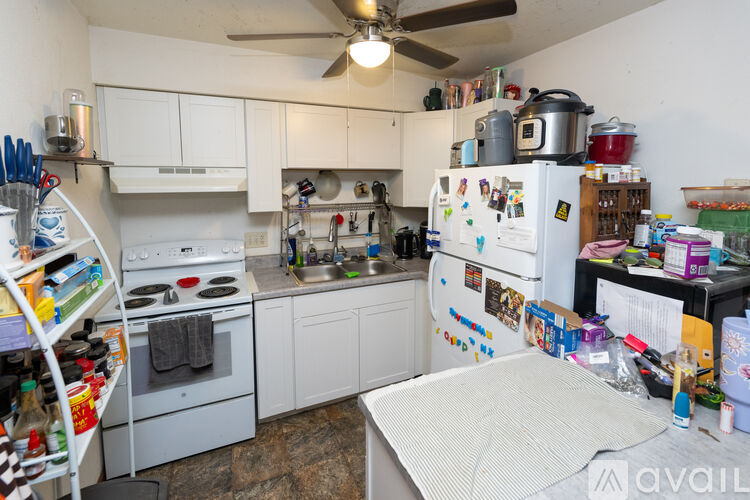 A small kitchen with a lot of items on the counter.