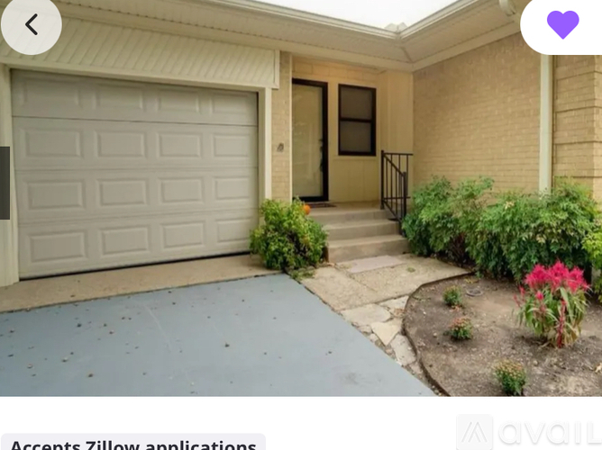 A house with a garage door and a sign that says "Accents Zillow applications".