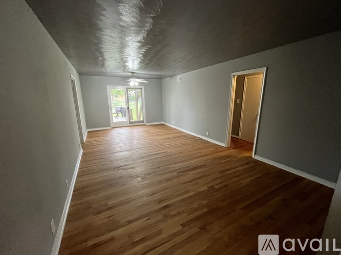 A room with wooden flooring and a window.