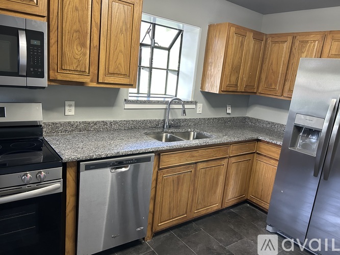 A kitchen with wooden cabinets and granite countertops.
