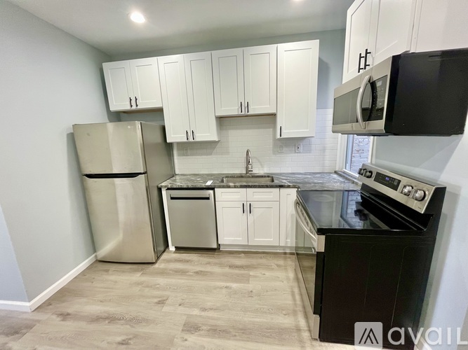 A kitchen with black countertops and white cabinets.