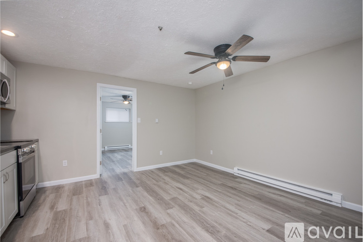 A room with a ceiling fan and wooden flooring.